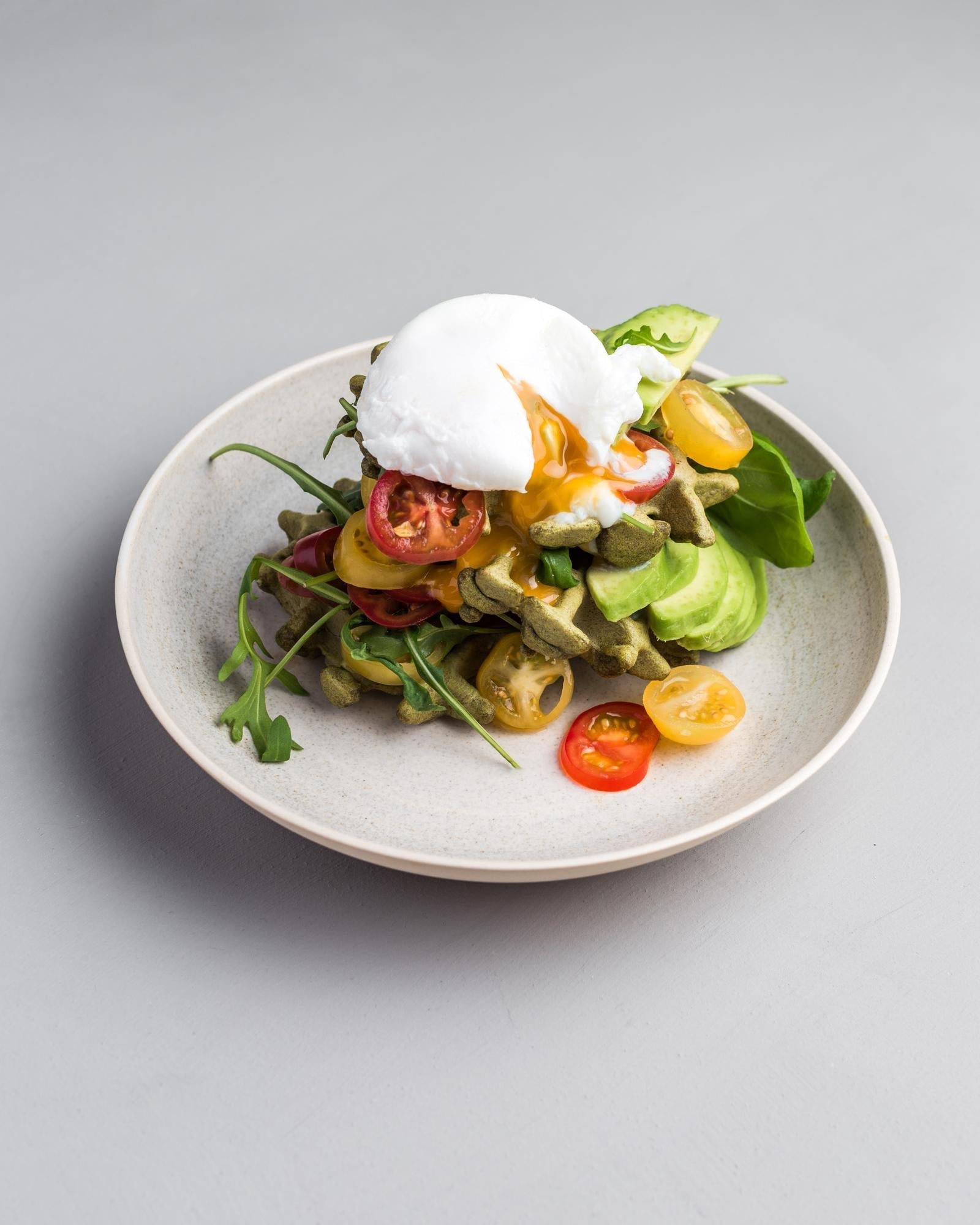 Waffle agli spinaci con pomodori, avocado e uovo in camicia